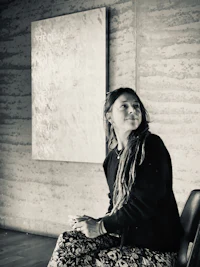 a woman sitting on a chair in front of a painting