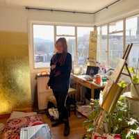 a woman standing in a room with a lot of plants